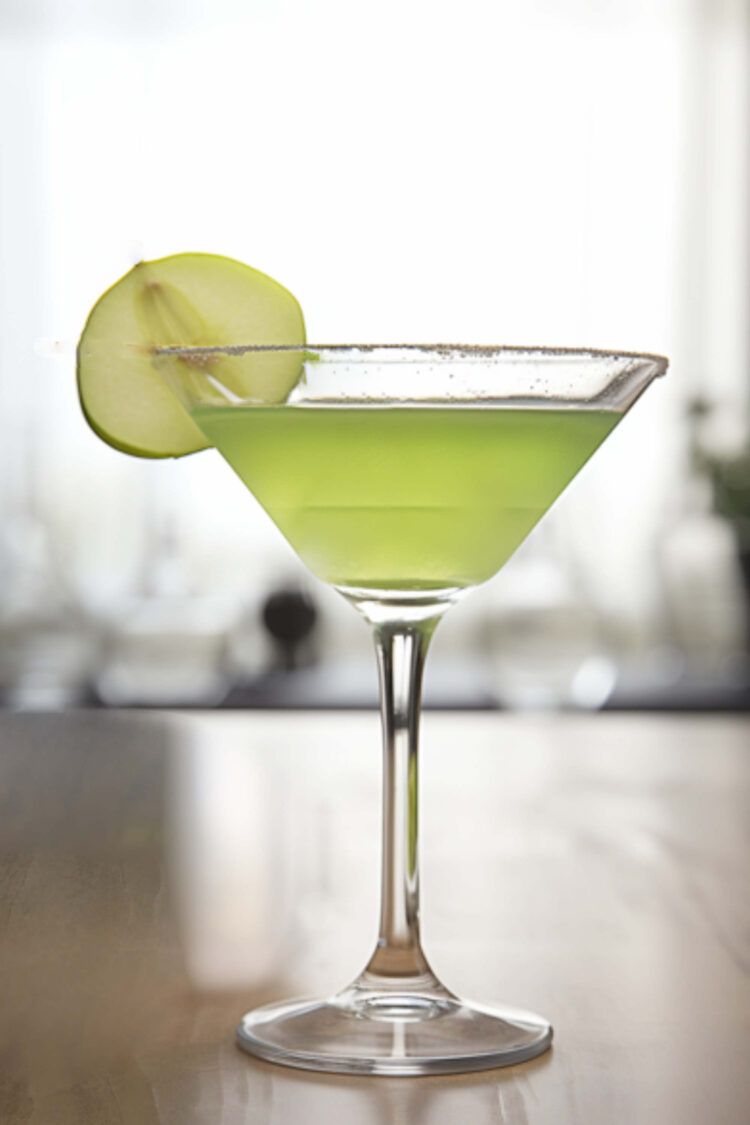 Appletini cocktail with apple slice garnish