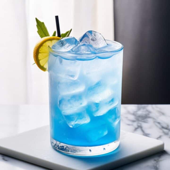 Blue Cowboy drink with mint and orange garnish