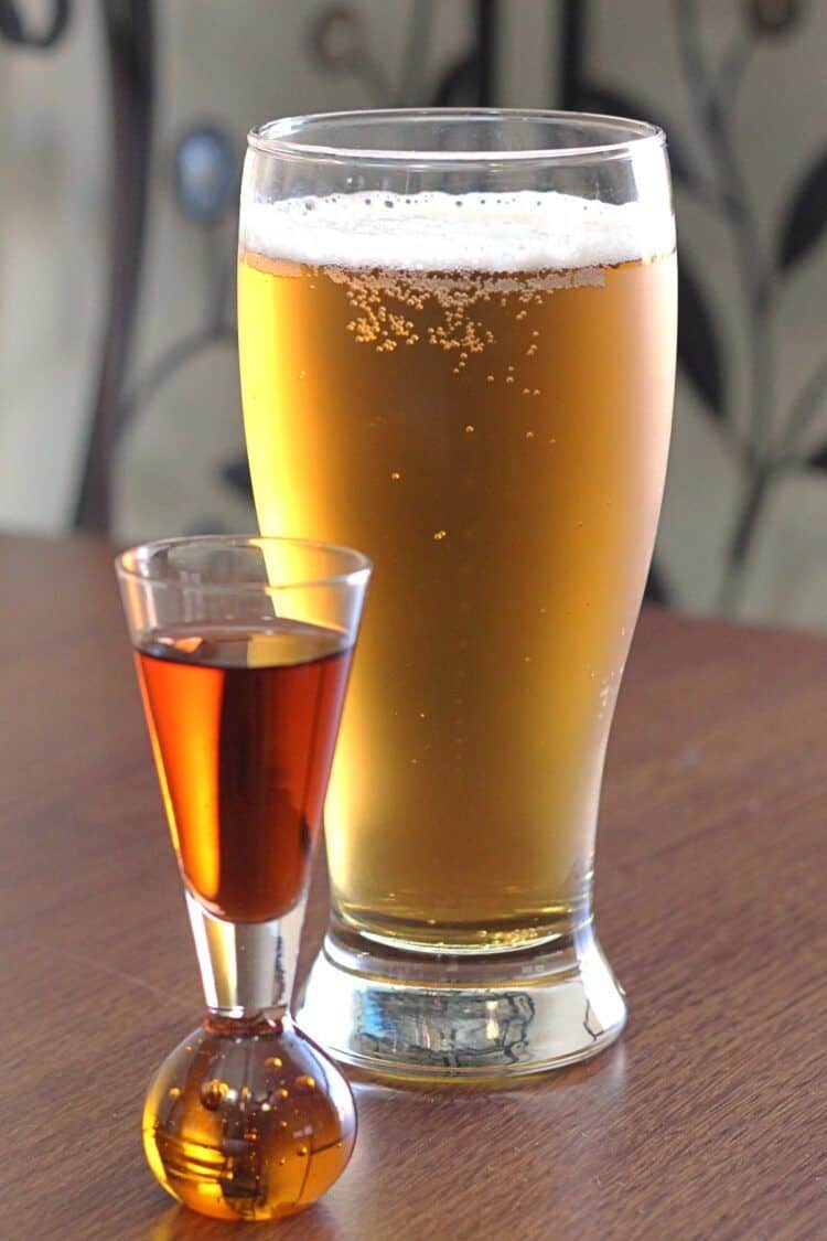 Boilermaker beer in Pilsner glass next to shot of whiskey