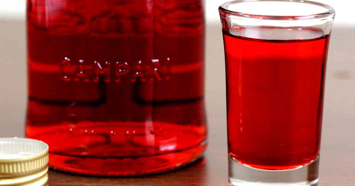 Bottle of Campari next to shot glass of same