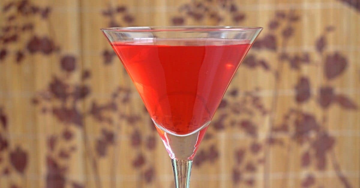 Vibrant red Centauri Sundown drink on table against patterned background