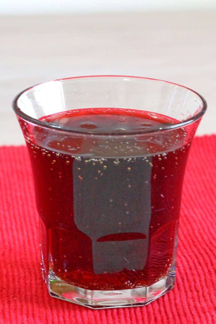 Cherry Coketail drink sitting on red placemat on table