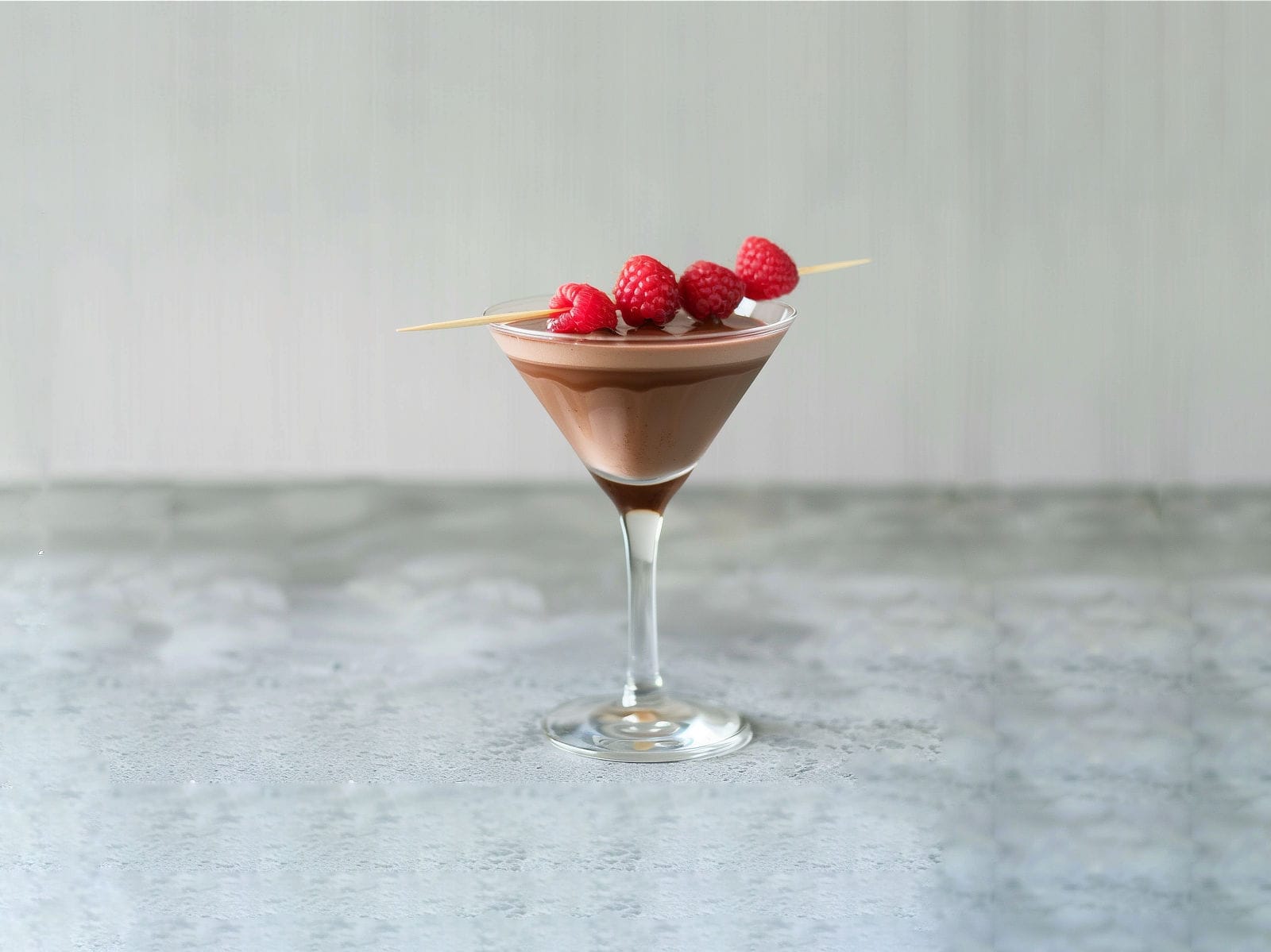 Chocolate Raspberry Martini with chocolate drizzle in glass and raspberry garnish