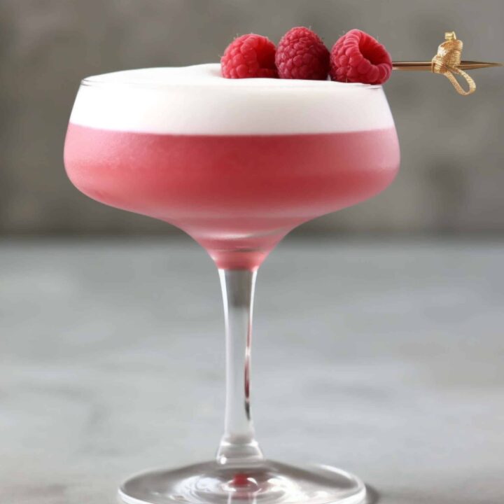 Clover Club Cocktail in coupe glass with raspberry garnish