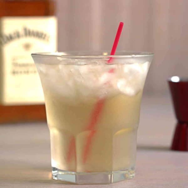 Closeup of Club Honey cocktail on table with red straw