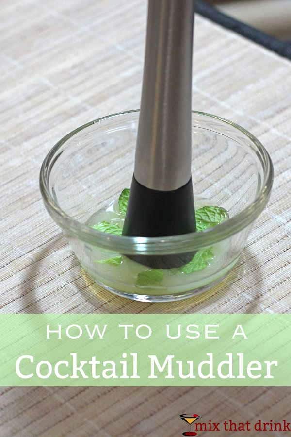 Cocktail Muddler crushing mint leaves in bowl