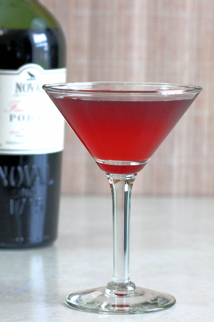 Crimson Cocktail in front of bottle of port