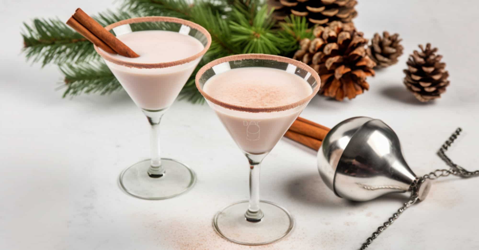 Two Eggnog Martinis surrounded by Christmas decorations