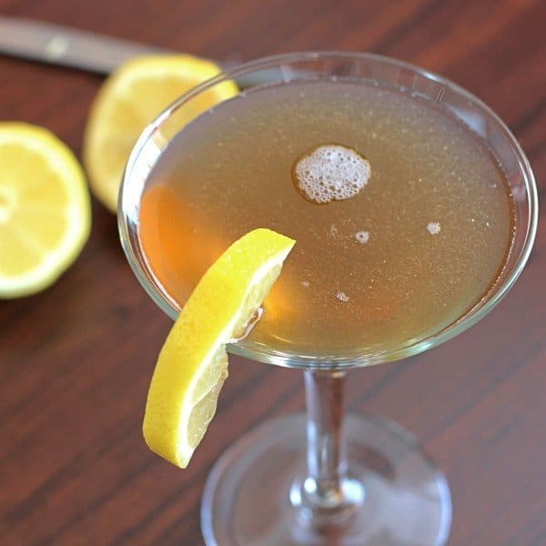 Closeup of lemon wedge on rim of Frisco Sour drink