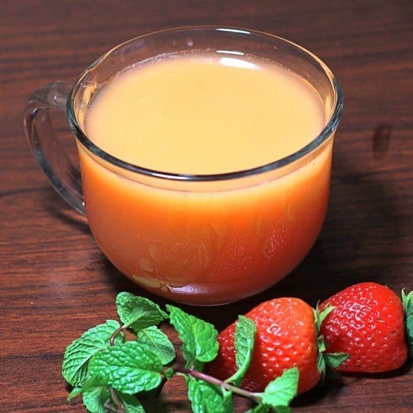 Overhead view of Gabbie's Punch in glass on table with strawberries