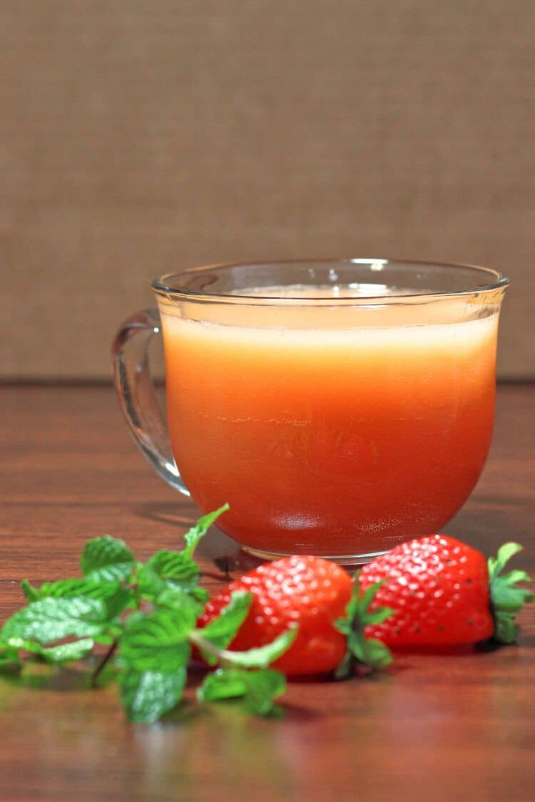 Gabbie's Punch in glass on table with strawberries