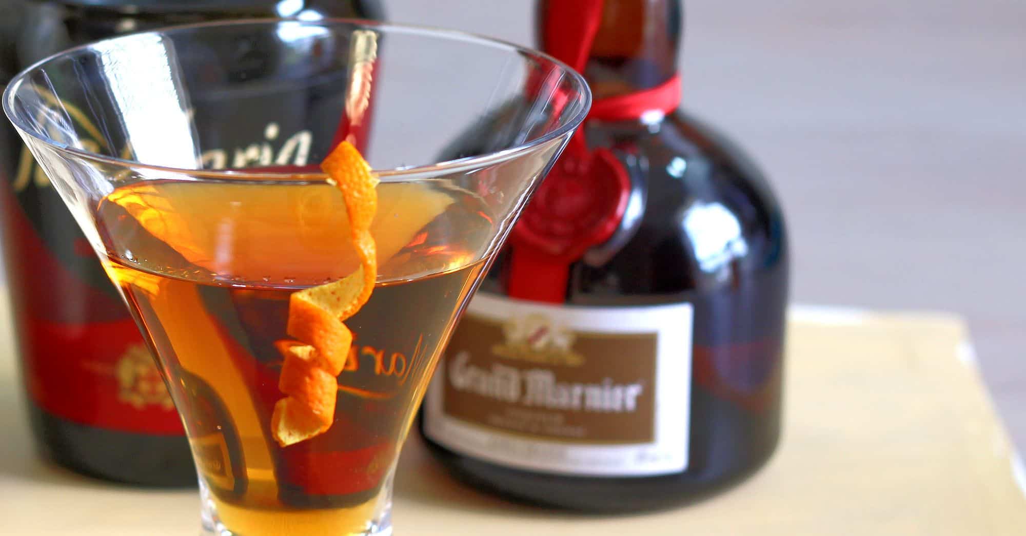 Bottle of Grand Marnier behind orange cocktail