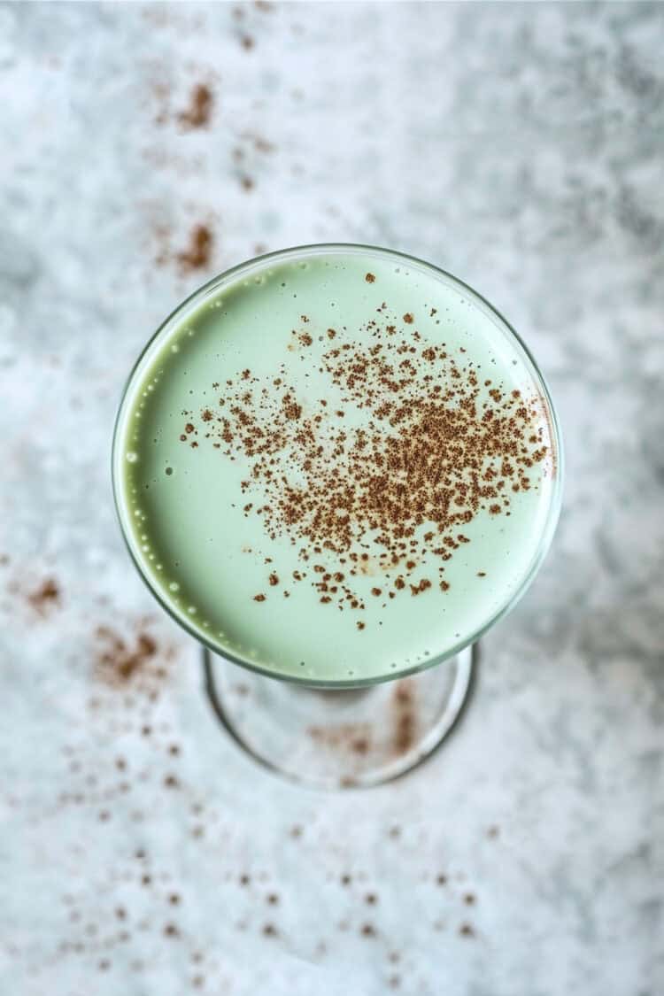 Creamy green Grasshopper drink with cocoa powder dusting on top