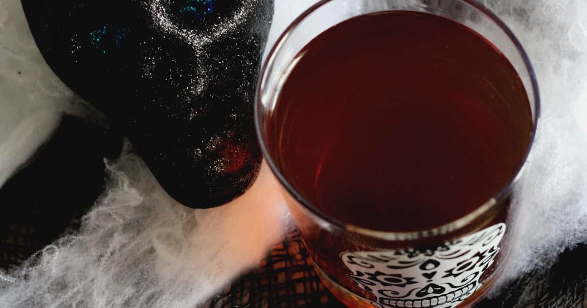 Cocktail surrounded by Halloween webbing and a black skull