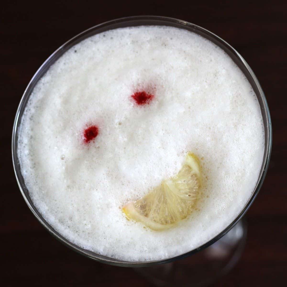 Happy Face drink recipe: gin, vodka, Cointreau, tonic, orange, pina colada, whole egg