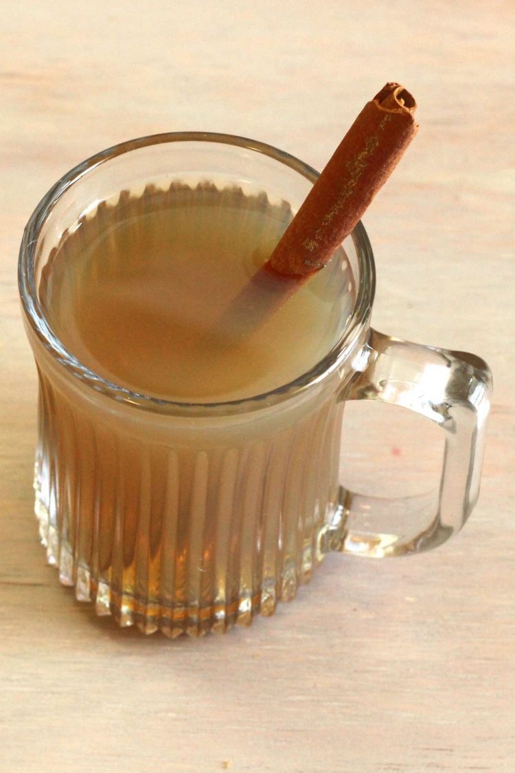 Angled overhead view of Hot Buttered Rum with cinnamon stick