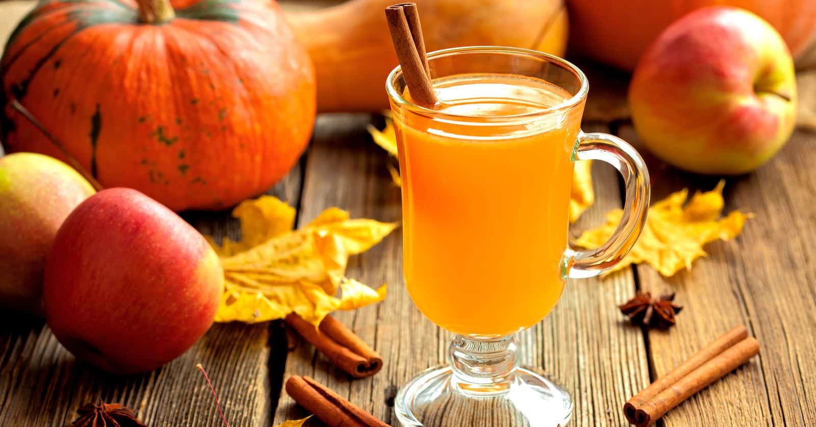 Hot Toddy cocktail on table with fall leaves and gourds