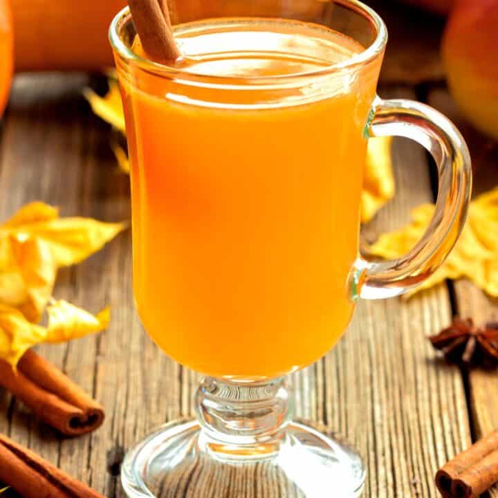 Hot Toddy cocktail on table with fall leaves and gourds