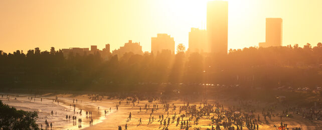 bright yellow sun setting over city and beach