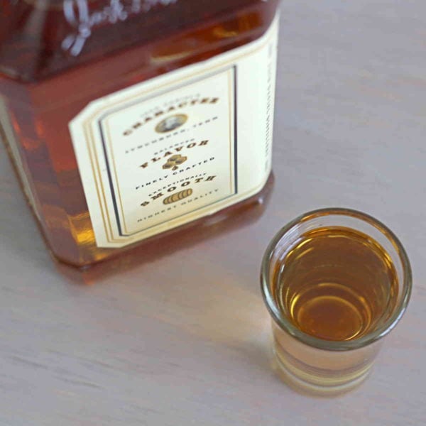 Overhead view of bottle of Jack Daniels Tennessee Honey next to shot glass of same