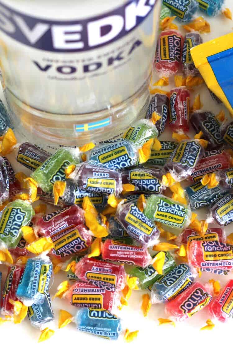 Bottle of vodka surrounded by wrapped Jolly Rancher candies