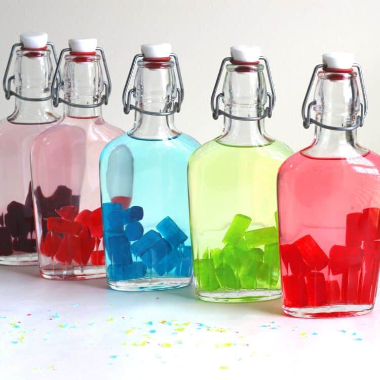 Jolly Rancher candies starting to color the vodka in a flask