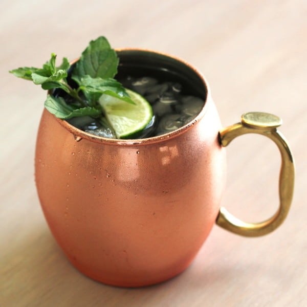 July Julep drink served in copper mug with mint sprig and lime wedge