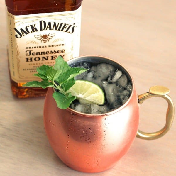 Overhead view of July Julep drink next to bottle of Jack Daniel's Honey