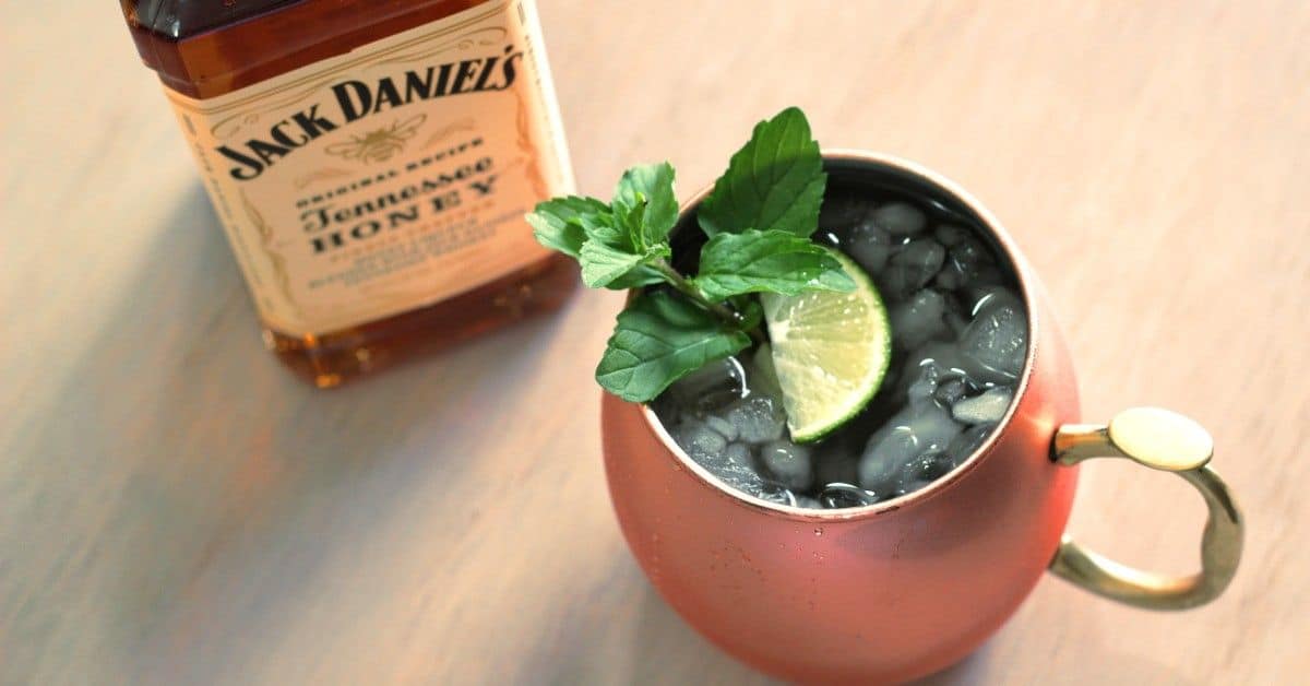 July Julep drink served in copper mug with mint sprig and lime wedge