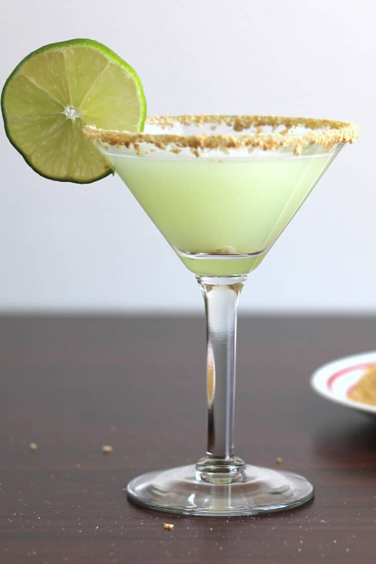 Key Lime Martini in glass with lime wheel and graham cracker crumb rim