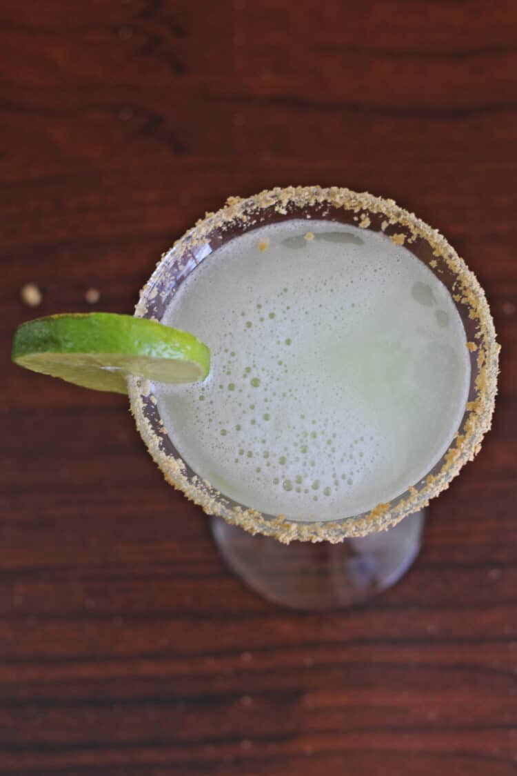 Overhead view of Key Lime Martini in glass with lime wheel and graham cracker crumb rim