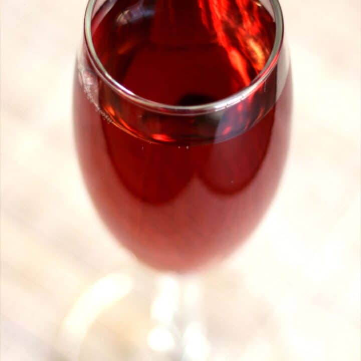 Kir Royale cocktail served in champagne flute on wooden bar top