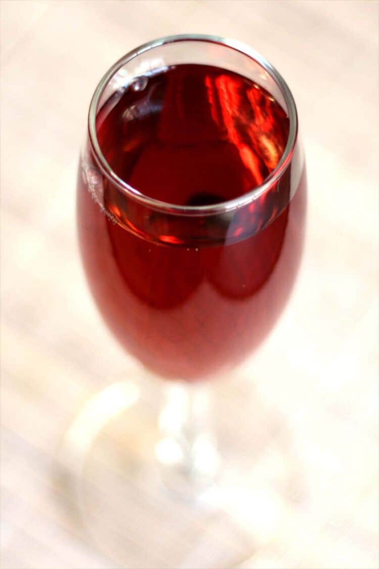 Kir Royale cocktail served in champagne flute on wooden bar top