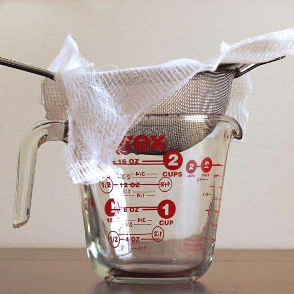 Cheese cloth in sieve in measuring cup