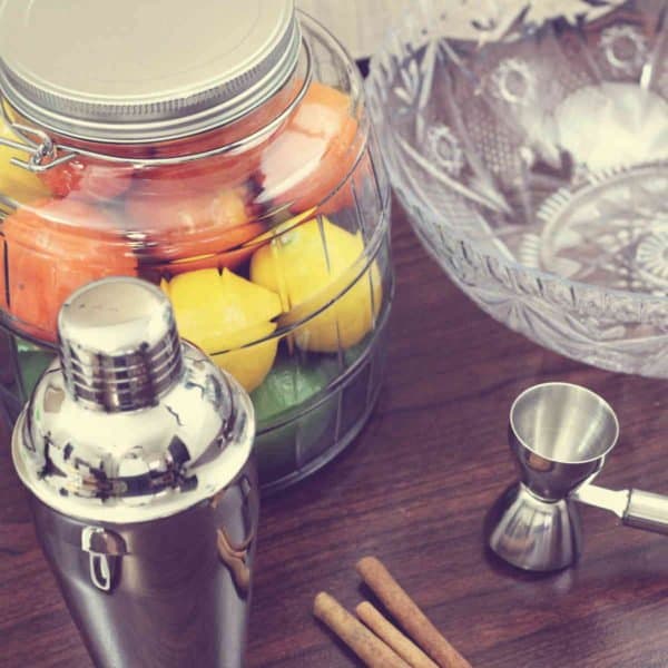 Fruit jar with cocktail shaker and jigger on bar top