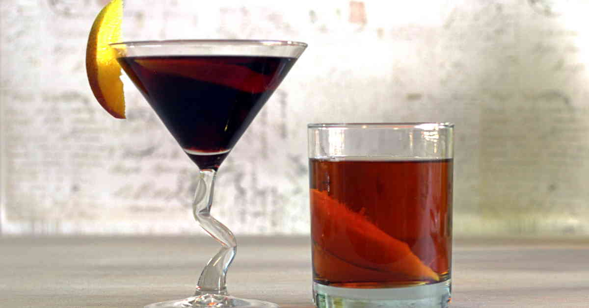 Two drinks with fruit garnish on table