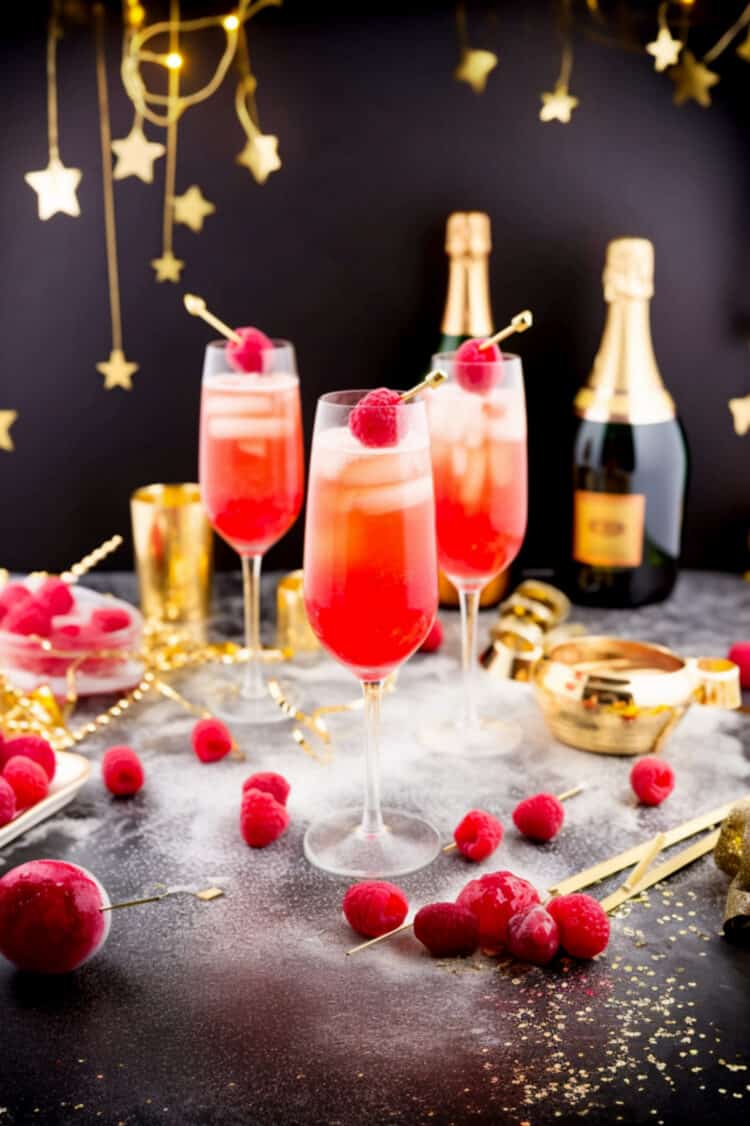 New Years Cocktails with raspberry garnish on table with holiday decorations