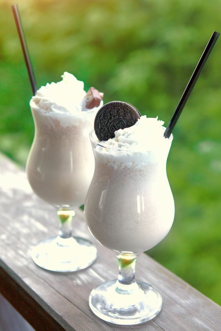 Two Pensacola Bushwacker drinks in parfait glasses on railing