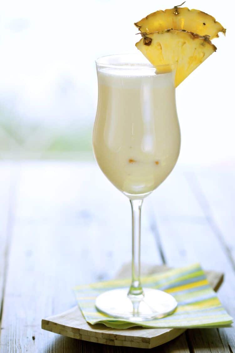 Pina Colada drink with pineapple wedges on table