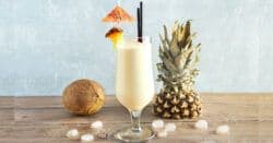 Pina Colada drink in front of coconut and pineapple