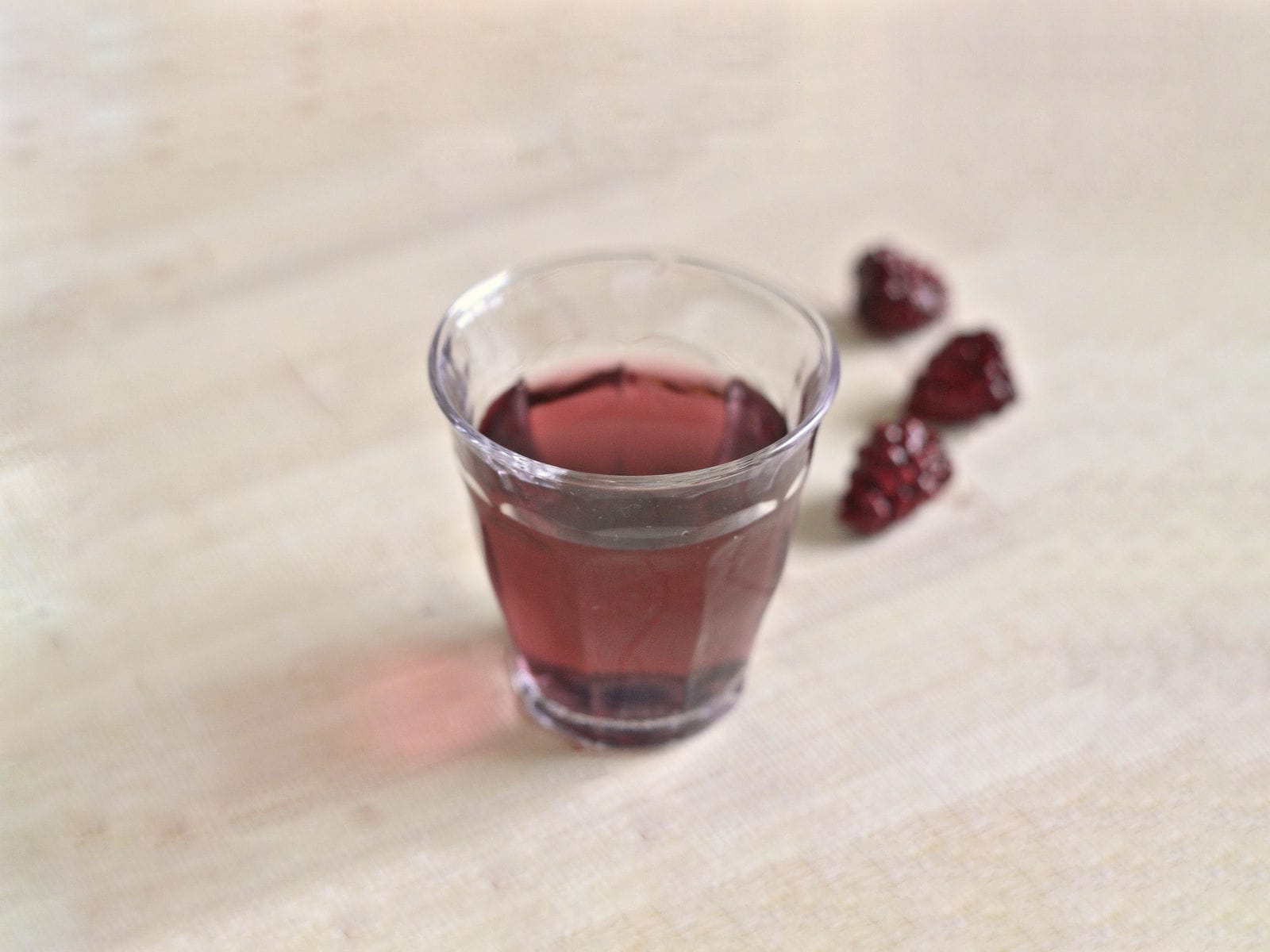 Purple Hooter Shooter on table with raspberries