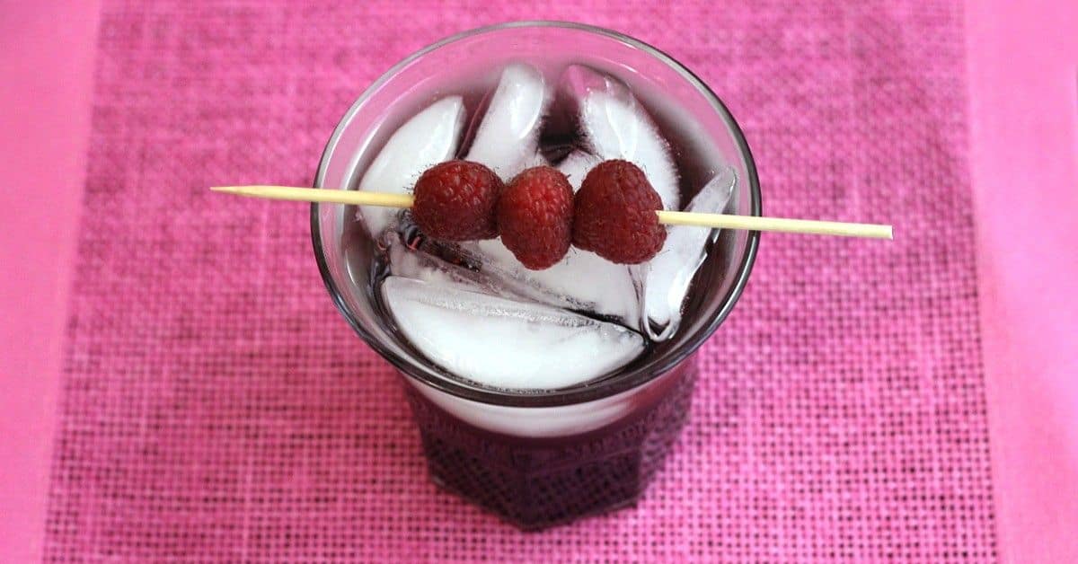 Raspberry Kamikaze drink with speared raspberries