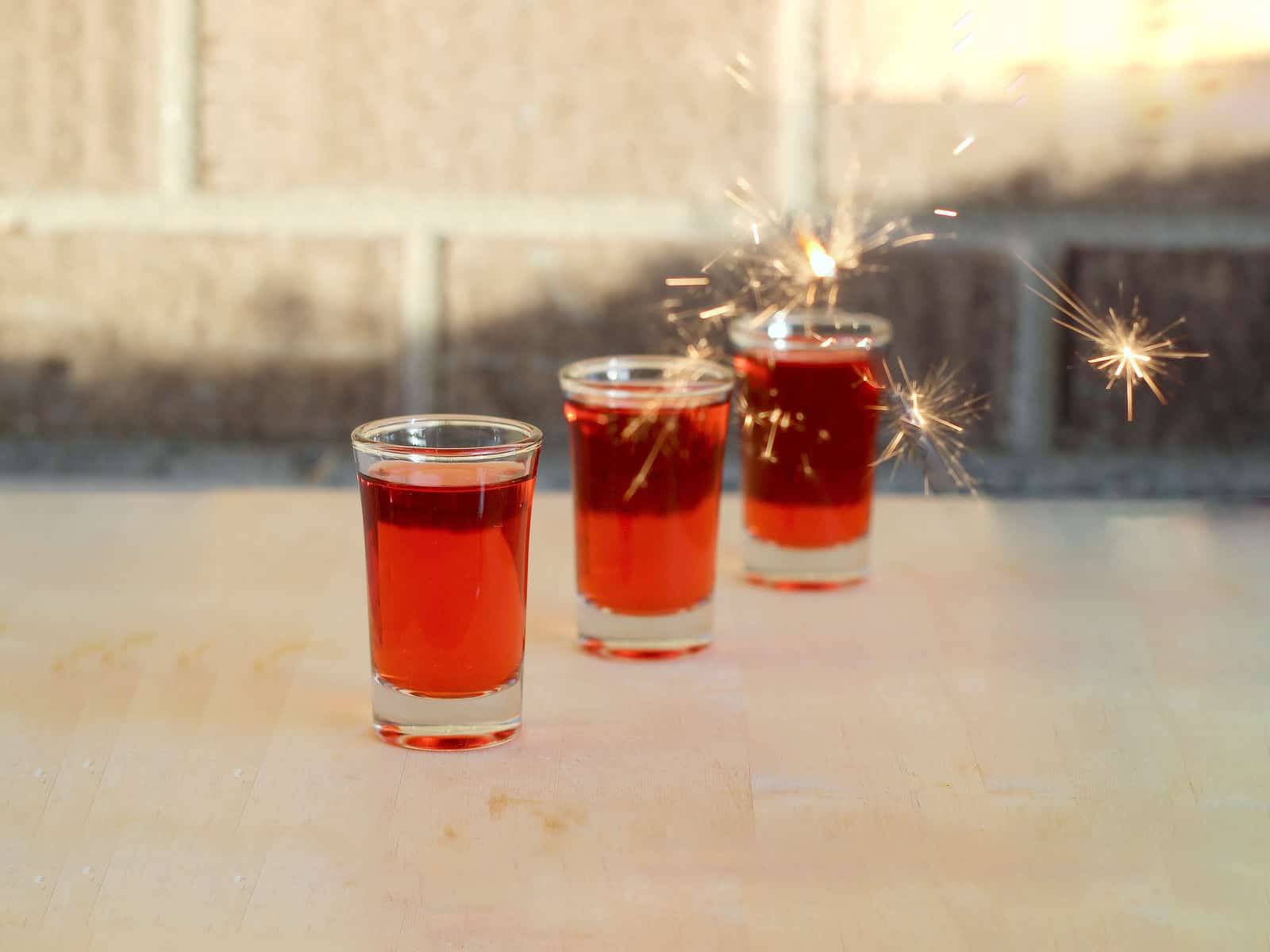 Red Hot Shot drinks lined up on bar with sparkler