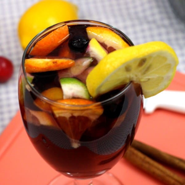 Closeup view of Sangria drink on cutting board with fruit