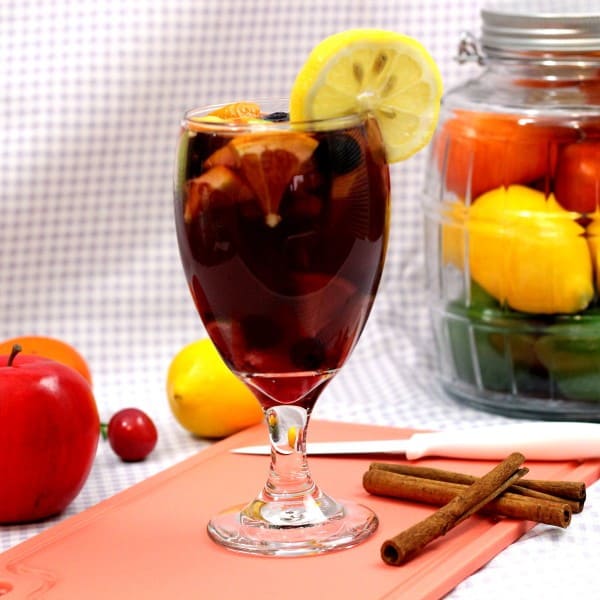 Full-length view of Sangria drink on cutting board with fruit