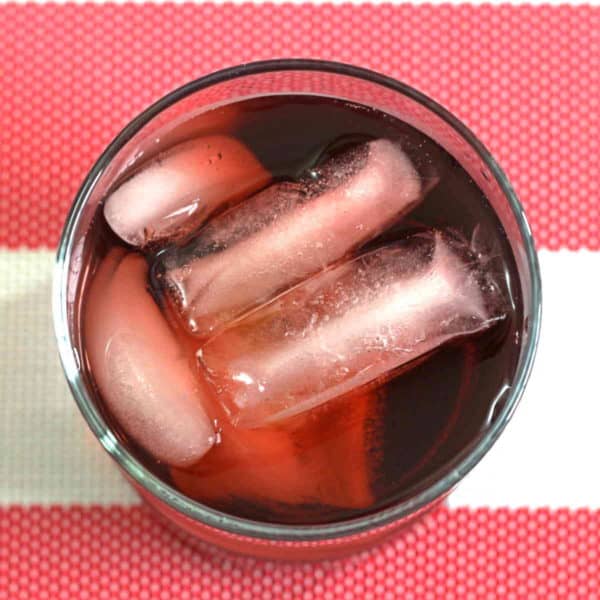 Overhead view of Spiced Watermelon Cooler drink on red and white tablecloth