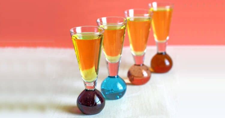 Four Sunny Mexico drinks lined up against an orange background