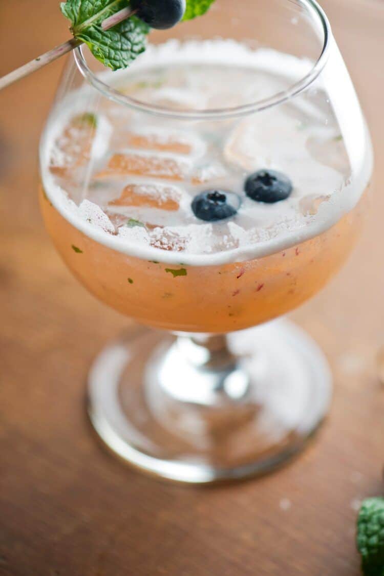 Closeup of Lion cocktail with blueberries and mint leaves