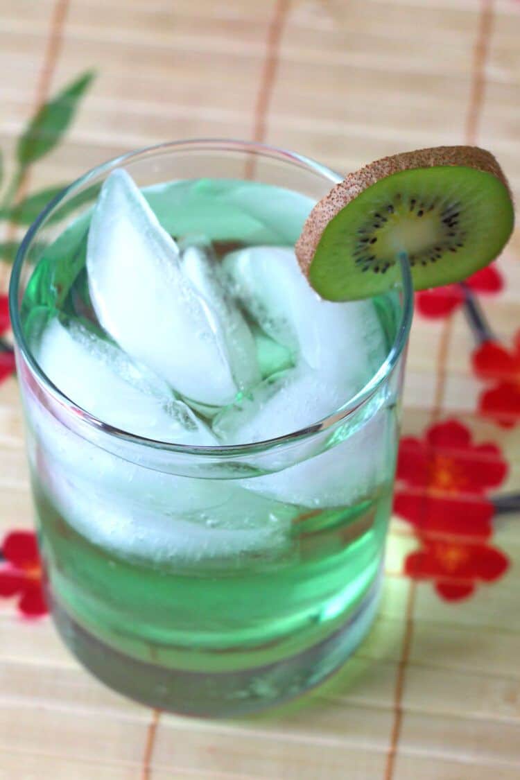 Angled view of Tokyo Iced Tea with kiwi slice on patterned placemat