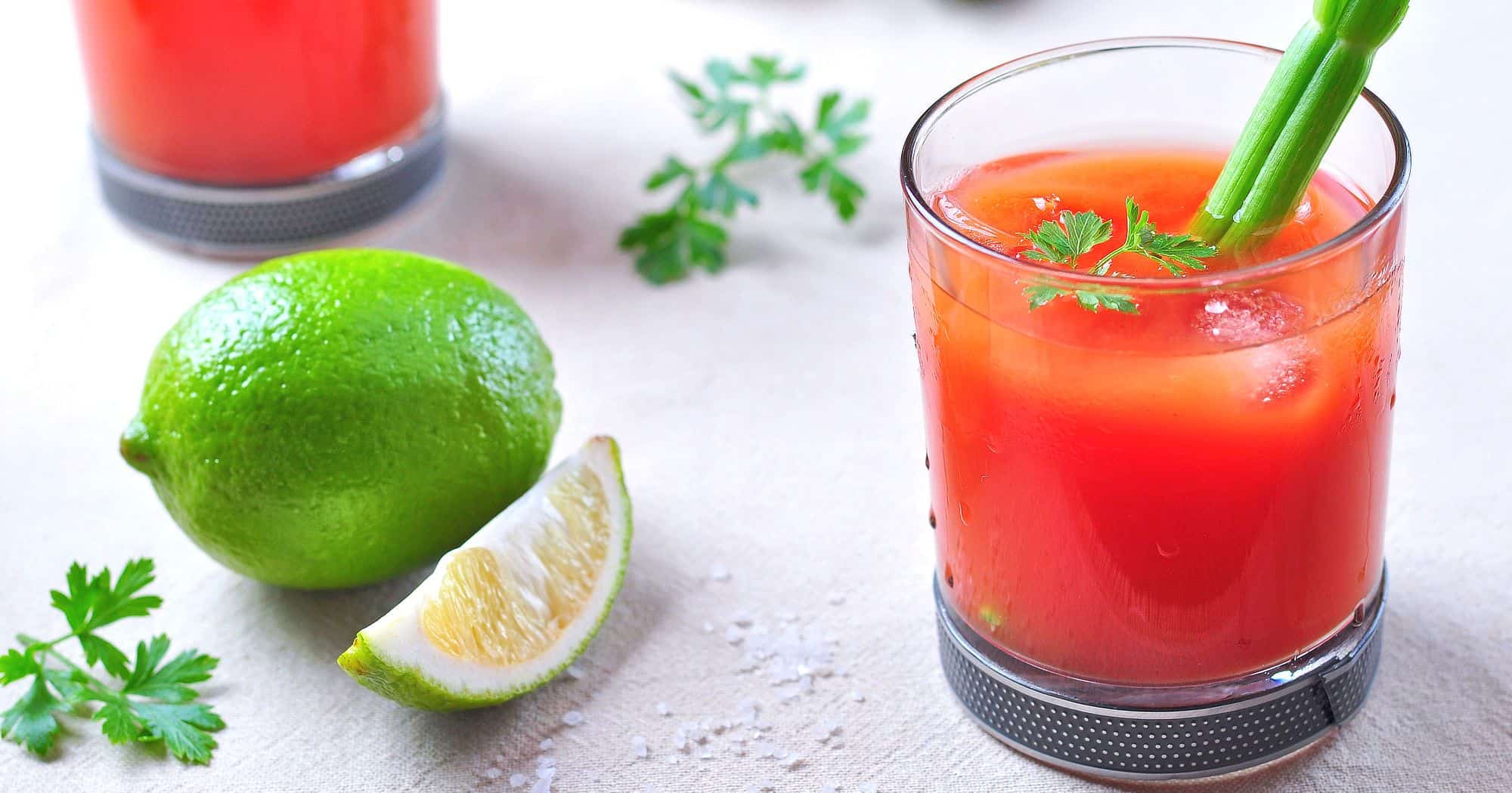 Virgin Mary mocktail with celery garnish and limes on table